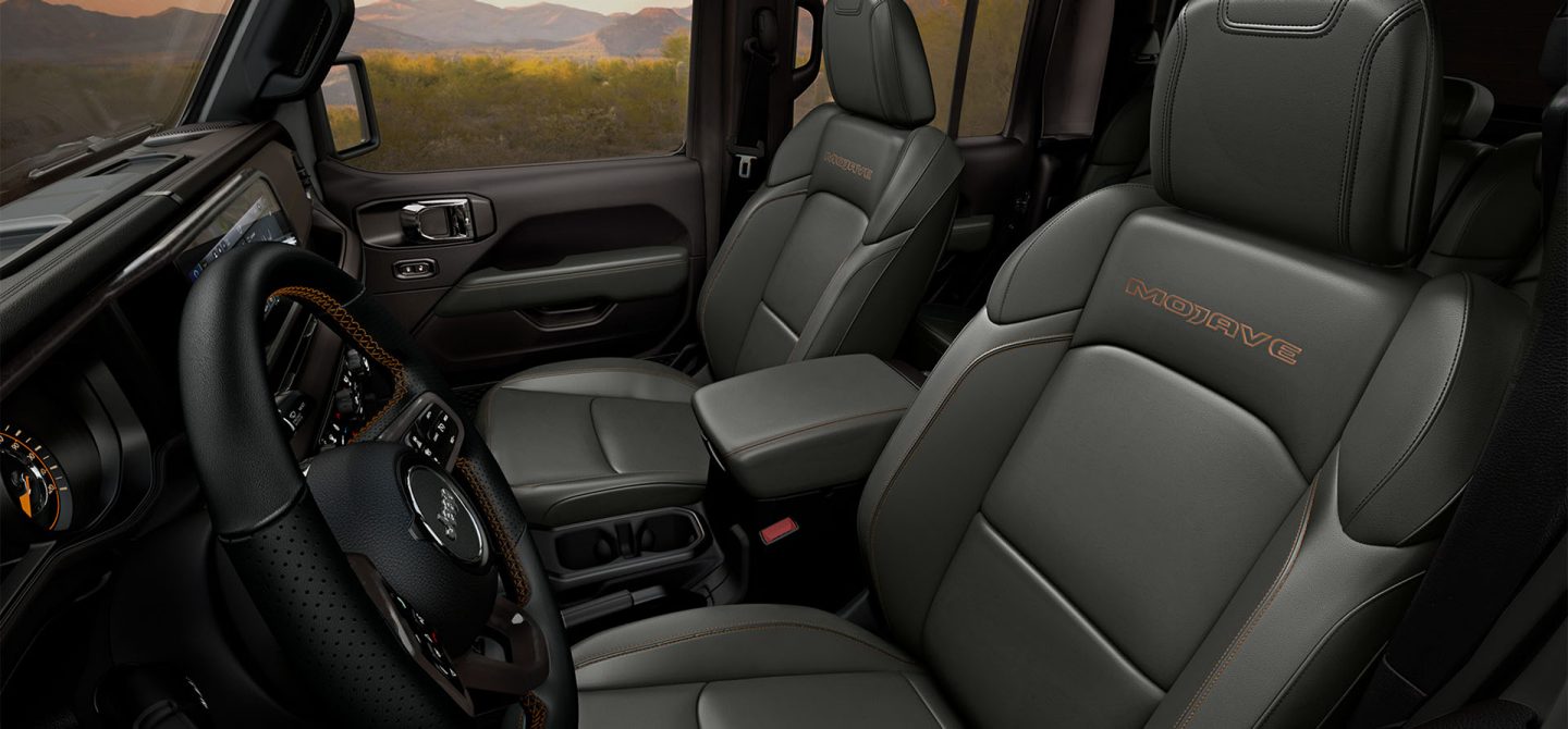 The front seats in the 2025 Jeep Gladiator Mojave, with "Mojave" embroidered on the seats, just below the headrests.