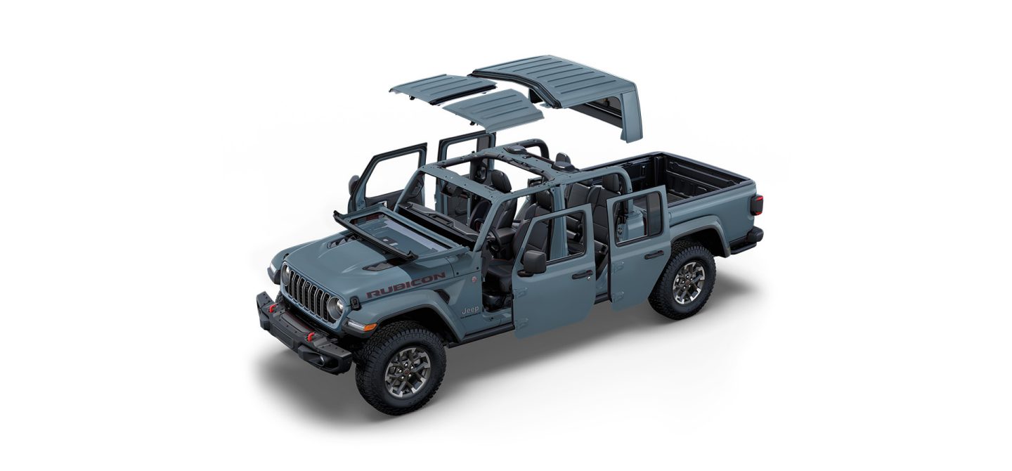 A gray 2025 Jeep Gladiator Rubicon X with the roof and doors detached and the windshield folded.