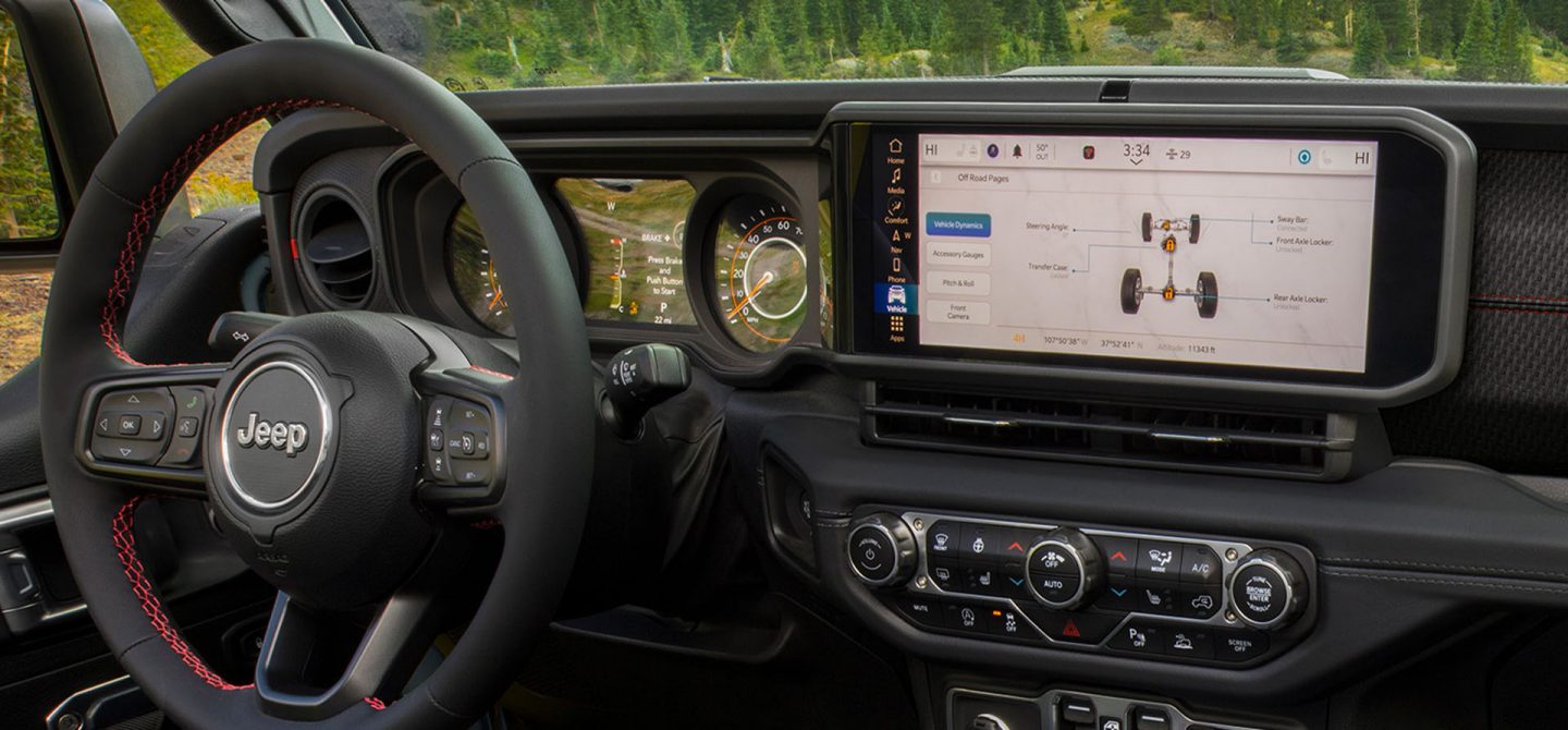 The steering wheel, Digital Cluster Display, Uconnect touchscreen and center stack controls in the 2025 Jeep Gladiator, with the touchscreen displaying the Vehicle Dynamics section of the Off-Road Pages.