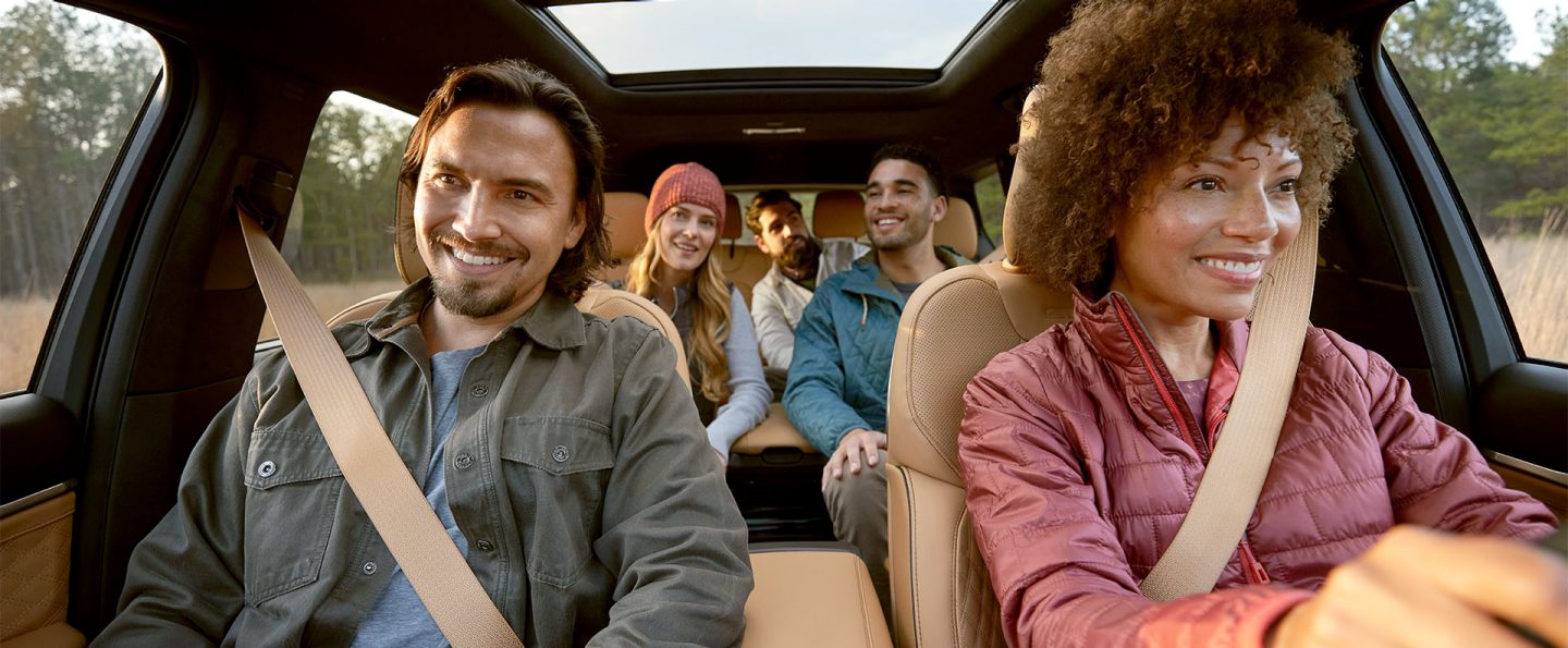 The interior of the 2025 Jeep Grand Cherokee L Summit Reserve with the driver and passenger in the front row, two passengers in the second row and one passenger in the third row.